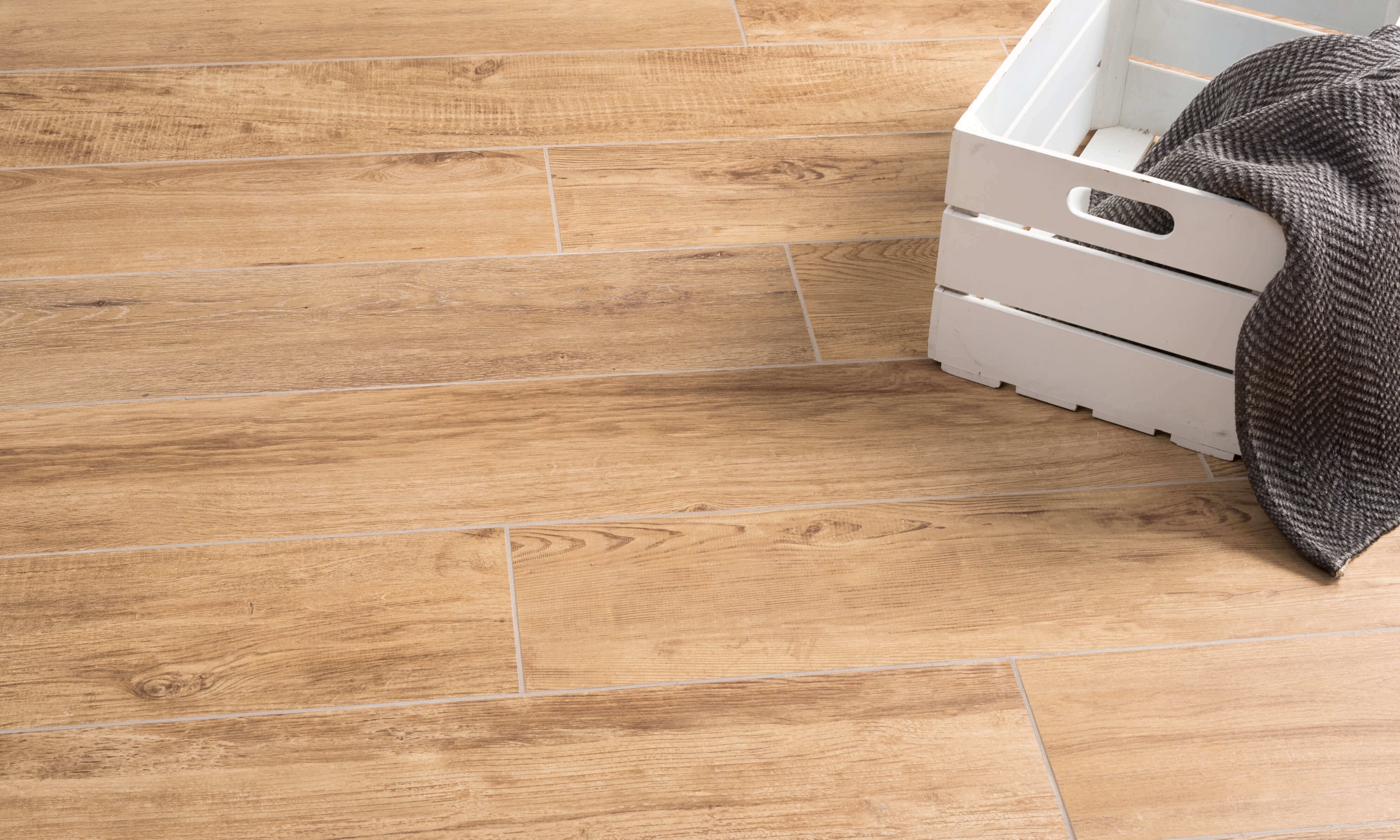 Boîte blanche sur le sol avec des carreaux en grès cérame en effet bois