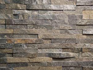 Vue frontale sur des plaquettes de parement en quartzite Deoli Green posées au mur
