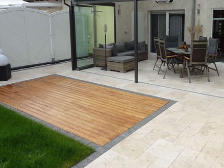 Photo du client : Dalles en travertin Medium SELECT, tambourinées, assemblage romain, posées sur une terrasse avec jardin d'hiver, pelouse et terrasse en bois