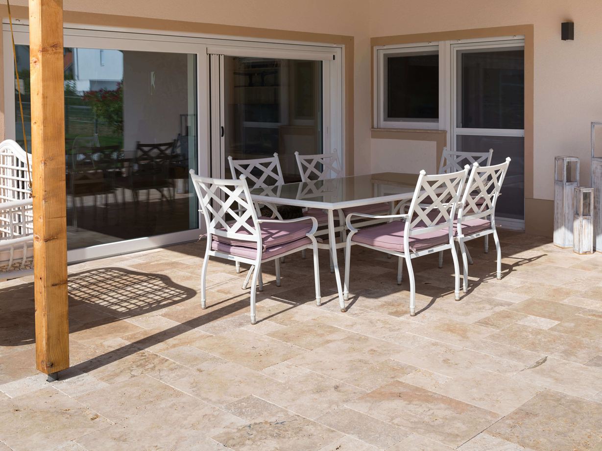 Terrasse en travertin et meubles blancs