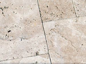 Gros plan sur les dalles en travertin beige clair avec des pores typiques du travertin