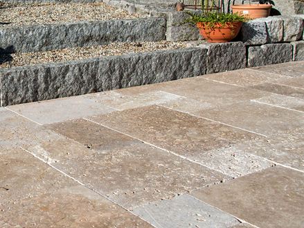 Terrasse avec dalles en travertin brun, au fond un escalier en granit