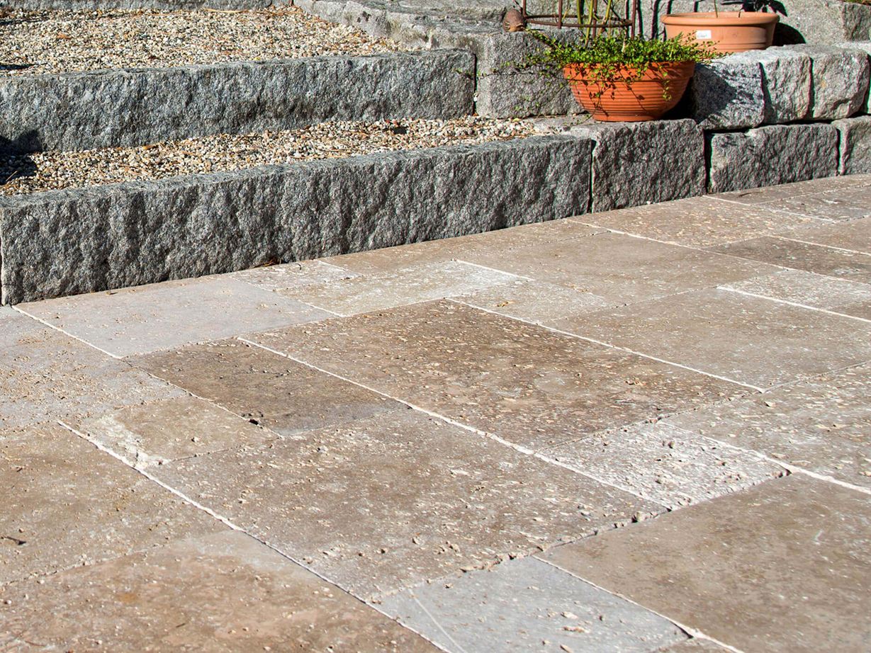 Terrasse avec dalles en travertin brun, au fond un escalier en granit