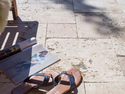 Magazine et sandales sur terrasse en travertin Rustic