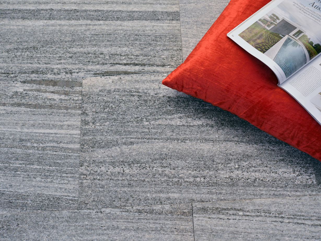 Dalles de granit Urban Grey Line avec coussin orange et magazine