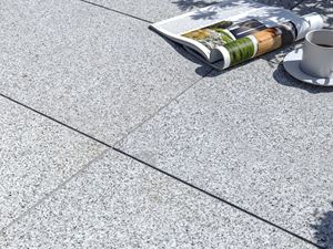 Dalles de terrasse en granite Silver Classico avec magazine et tasse de café