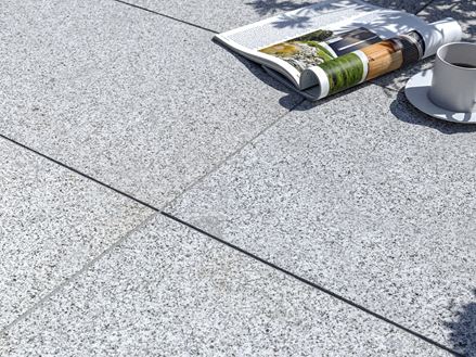 Dalles de terrasse en granite Silver Classico avec magazine et tasse de café
