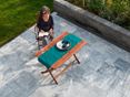 Femme assise à une table en bois sur une terrasse avec des dalles de marbre