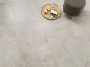  Un tabouret, un plateau et du savon posés sur le dallage effet béton Concrete Stone