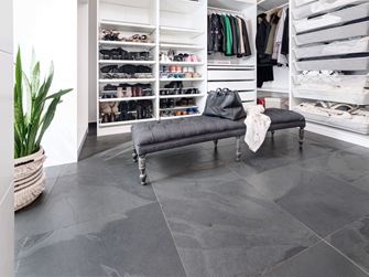 Dressing avec banc gris, armoires ouvertes blanches, carrelage en ardoise Mustang en revêtement de sol