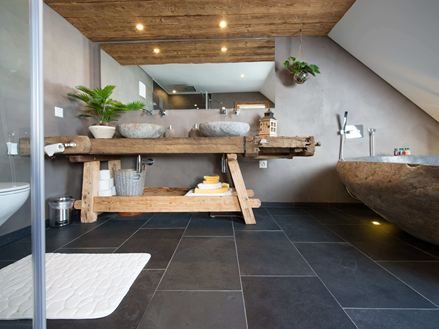 Une salle de bain rustique avec un sol en ardoise et des meubles en bois