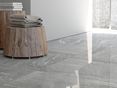  L'association du carrelage effet pierre et des meubles en bois dans la salle de bain.
