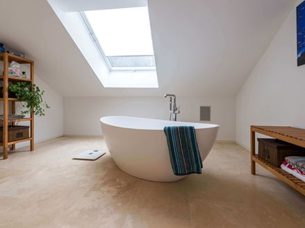 Salle de bain avec travertin Medium Line, baignoire sur pied et serviette de bain