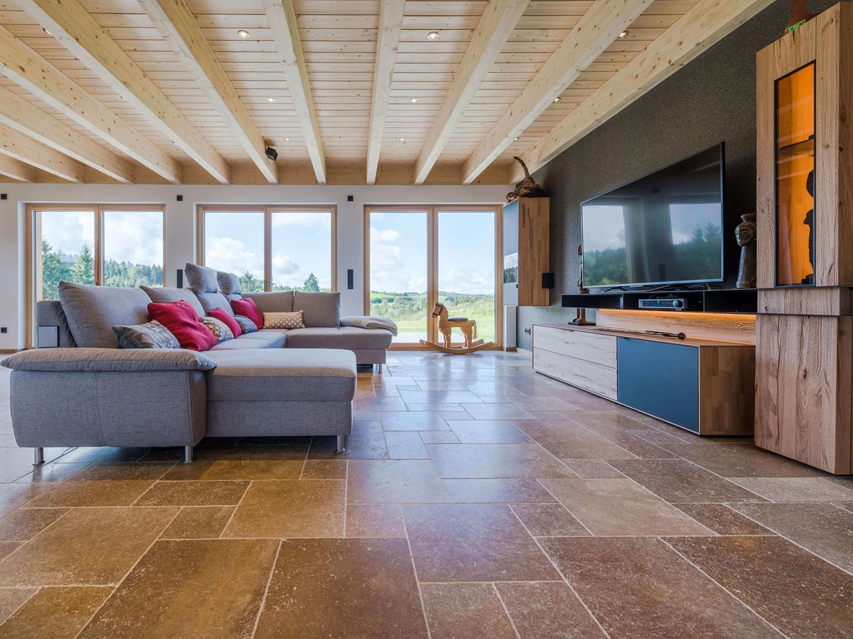 Salon avec sofa et revêtement de sol en travertin Noce dans les tons bruns