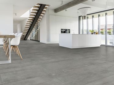 Une salle à manger moderne, un escalier et des carreaux effet béton Concrete Smoke au sol
