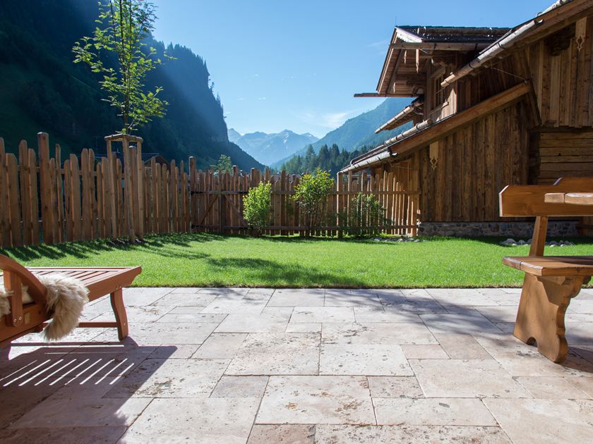 terrasse en travertin, chaise et table en bois avec vue sur alpes