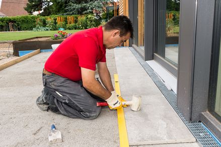 Le carreleur pose des carreaux de grès cérame sur la terrasse