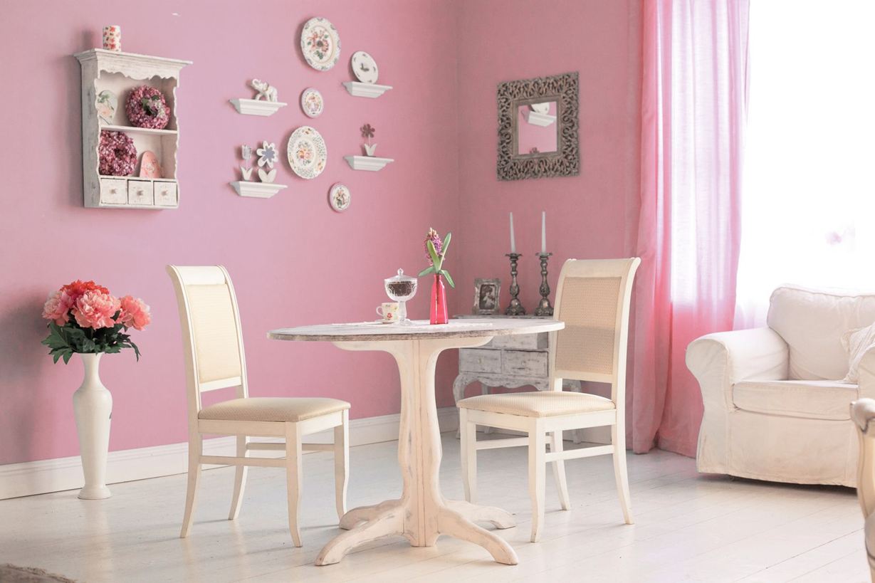 Chambre avec des meubles blancs et un mur rose dans un style romantique